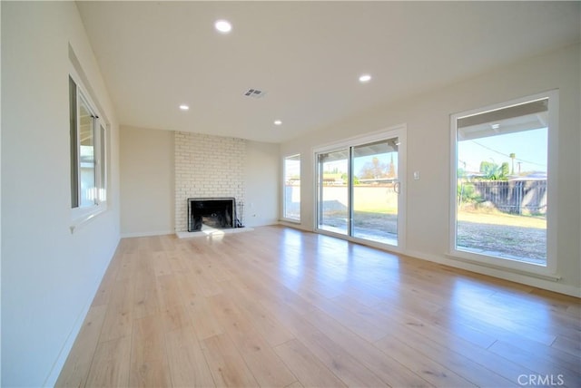 unfurnished living room featuring a fireplace, recessed lighting, visible vents, and light wood finished floors