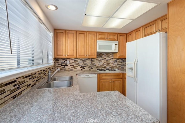 kitchen with white appliances, a sink, and tasteful backsplash