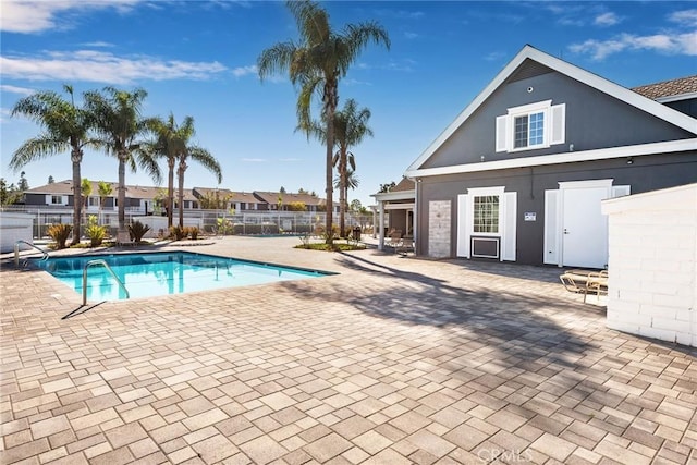 community pool featuring a patio and fence