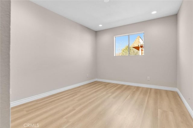 unfurnished room featuring recessed lighting, light wood-type flooring, and baseboards