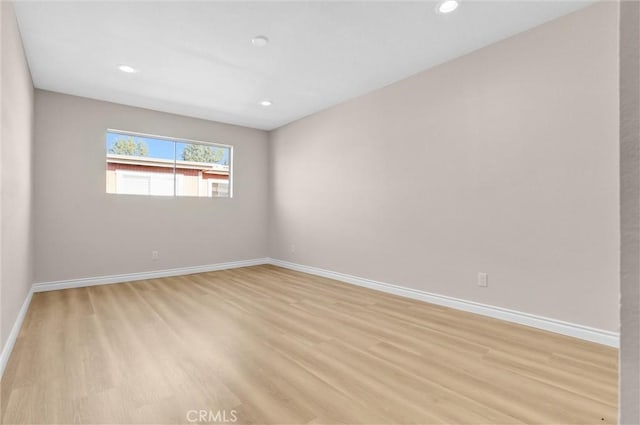 empty room featuring recessed lighting, light wood-style floors, and baseboards