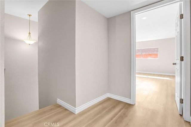 hallway with baseboards and light wood finished floors