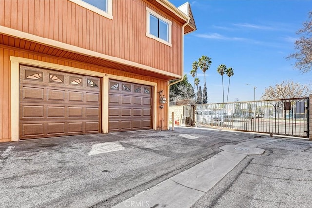 garage with fence and driveway