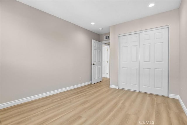 unfurnished bedroom featuring visible vents, recessed lighting, a closet, light wood-style floors, and baseboards