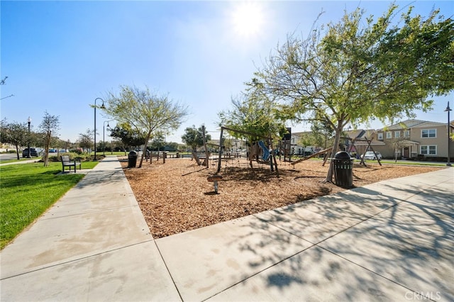 view of property's community with a lawn and playground community