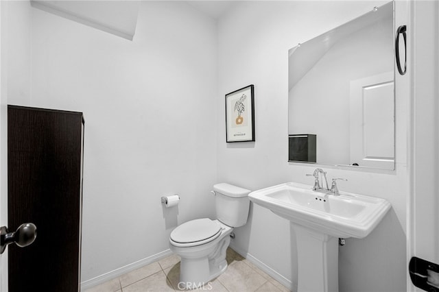 bathroom with tile patterned flooring, toilet, baseboards, and a sink