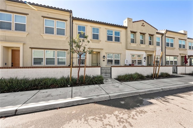 view of front of house with stucco siding, a residential view, and a fenced front yard