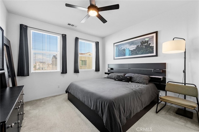 carpeted bedroom with visible vents, a ceiling fan, and baseboards