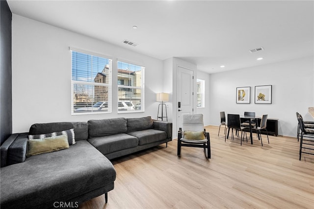 living room with recessed lighting, visible vents, and light wood-style floors