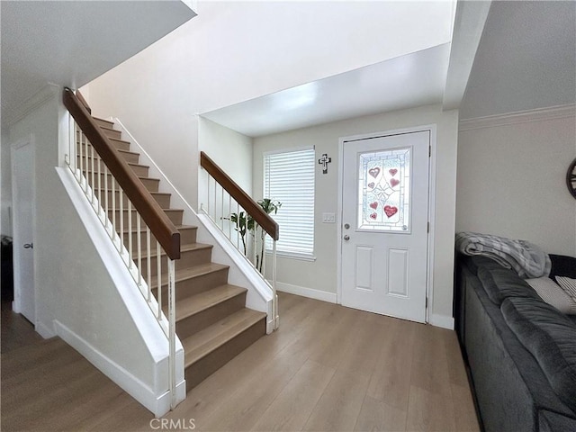 entryway with stairway, light wood-style flooring, and baseboards