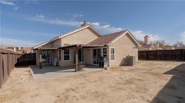 rear view of property featuring a patio, cooling unit, a fenced backyard, and stucco siding