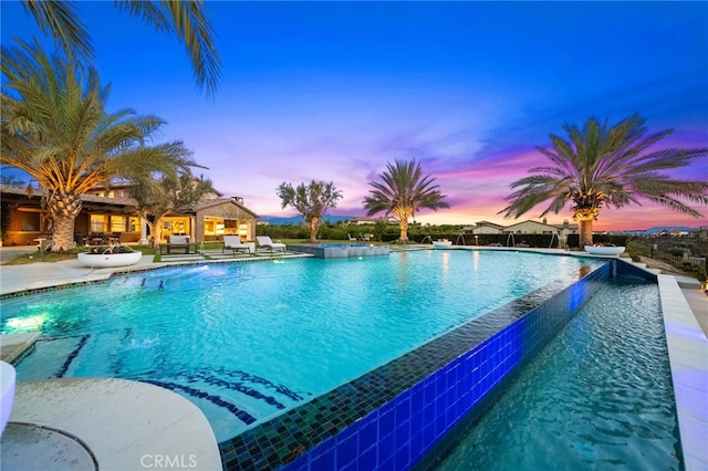 view of pool with a patio area and an infinity pool