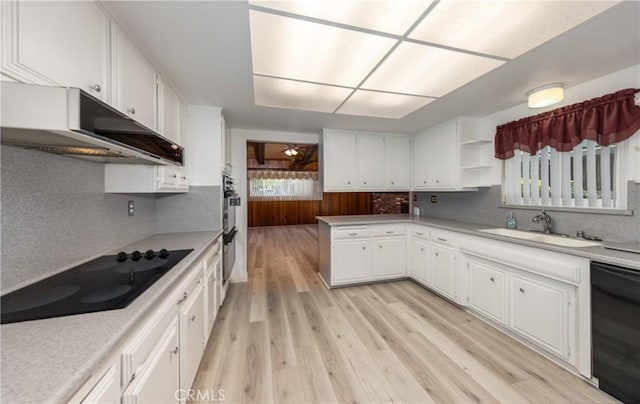 23187 Glendora Dr, Grand Terrace, CA 92313 - kitchen featuring black appliances, under cabinet range hood, a sink, light wood-style flooring, and white cabinetry