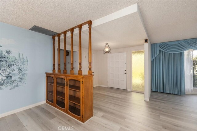 23187 Glendora Dr, Grand Terrace, CA 92313 - foyer featuring wood finished floors, a textured ceiling, and baseboards