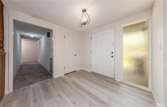 23187 Glendora Dr, Grand Terrace, CA 92313 - foyer entrance with light wood-type flooring, baseboards, and a textured ceiling