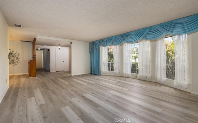 23187 Glendora Dr, Grand Terrace, CA 92313 - unfurnished living room featuring a textured ceiling, wood finished floors, and baseboards