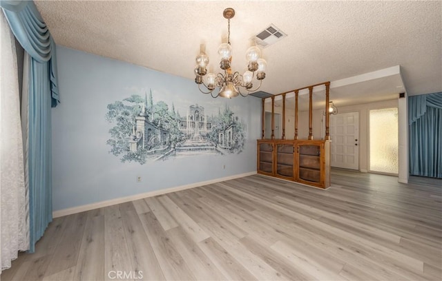23187 Glendora Dr, Grand Terrace, CA 92313 - unfurnished living room with a chandelier, wood finished floors, a textured ceiling, and baseboards