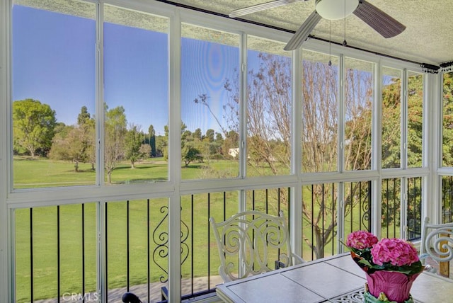 unfurnished sunroom featuring a ceiling fan