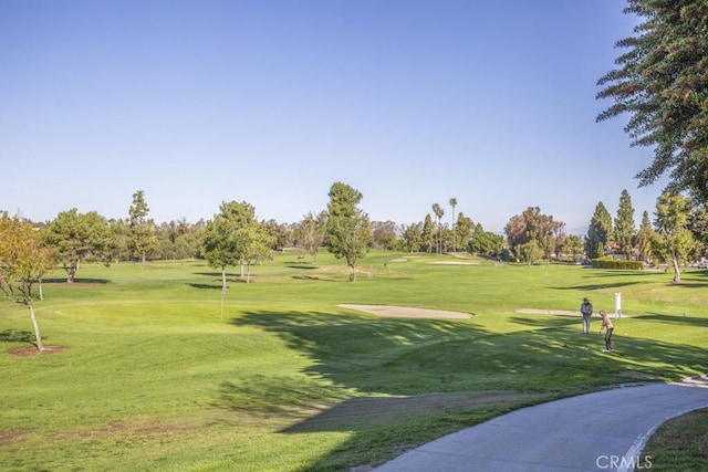 surrounding community with a lawn and golf course view