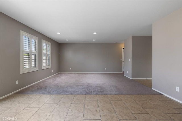 spare room with visible vents, recessed lighting, light colored carpet, and baseboards