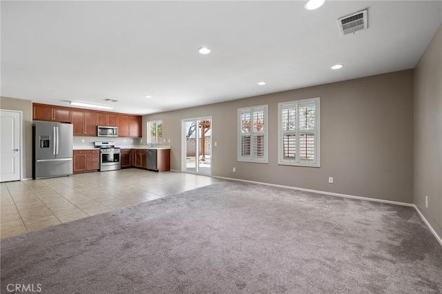 unfurnished living room featuring light tile patterned floors, recessed lighting, visible vents, and light carpet