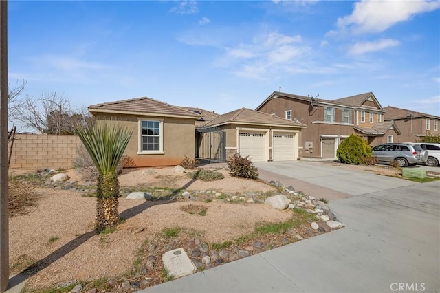 view of front of home featuring a gate, fence, stucco siding, concrete driveway, and a garage