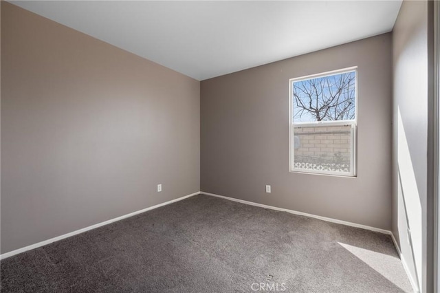 empty room featuring baseboards and carpet floors