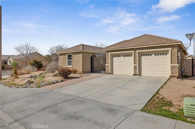 ranch-style home with a gate, stucco siding, a garage, stone siding, and a tiled roof