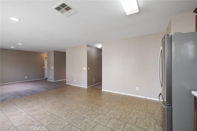 unfurnished room with baseboards, visible vents, light tile patterned flooring, recessed lighting, and light carpet