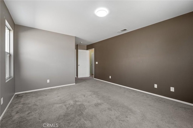 carpeted empty room featuring visible vents and baseboards