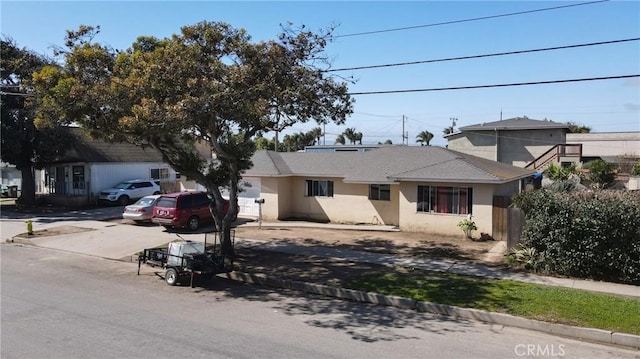 single story home with driveway and stucco siding