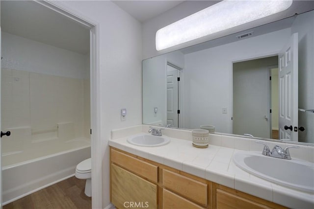 full bathroom featuring a sink, visible vents, toilet, and wood finished floors