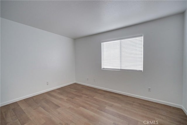 unfurnished room featuring light wood-type flooring and baseboards