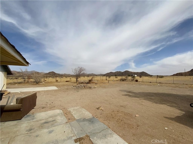 view of yard with a rural view and a mountain view