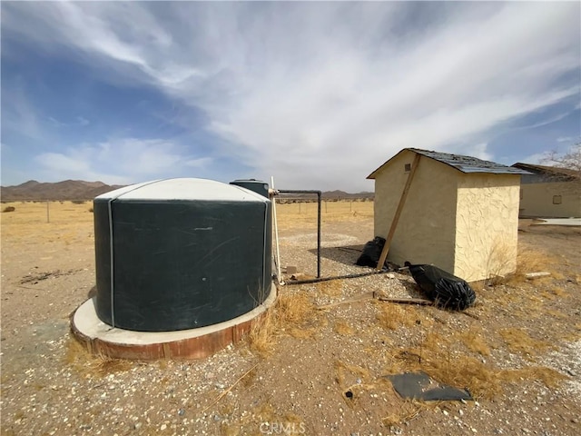 view of yard featuring a mountain view, an outbuilding, and a storage shed