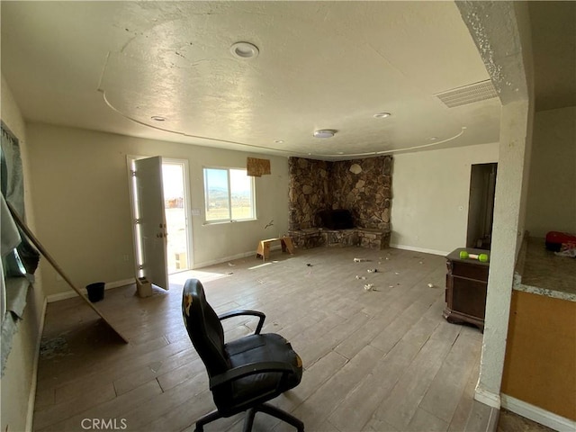 living room with a fireplace, baseboards, and wood finished floors