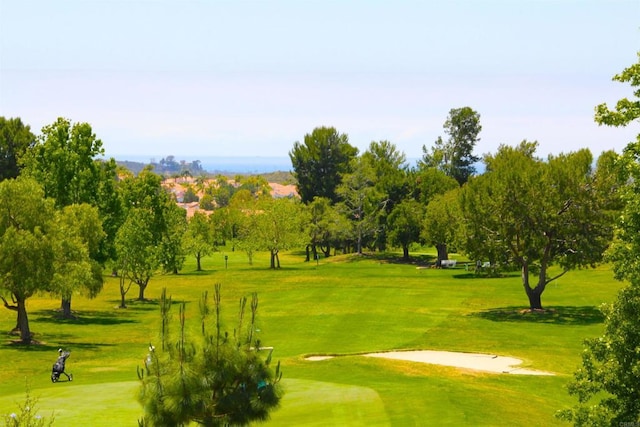 view of home's community with golf course view and a lawn