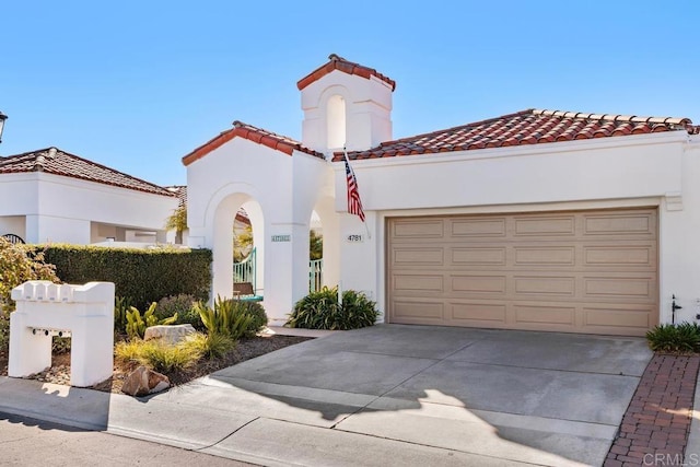 mediterranean / spanish-style house with stucco siding, a garage, driveway, and a tiled roof