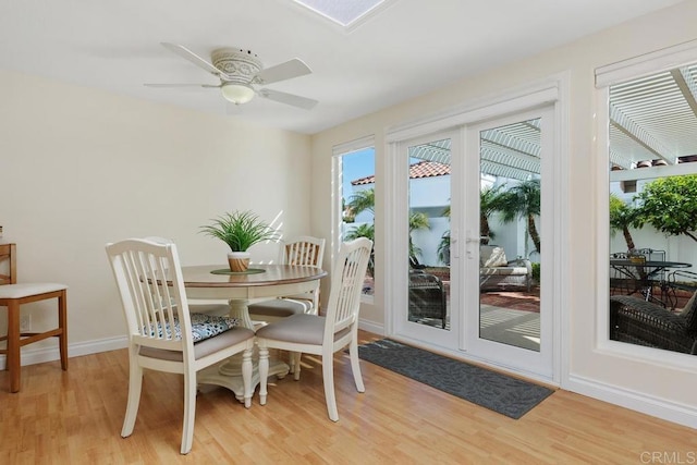 dining room with french doors, baseboards, light wood finished floors, and ceiling fan