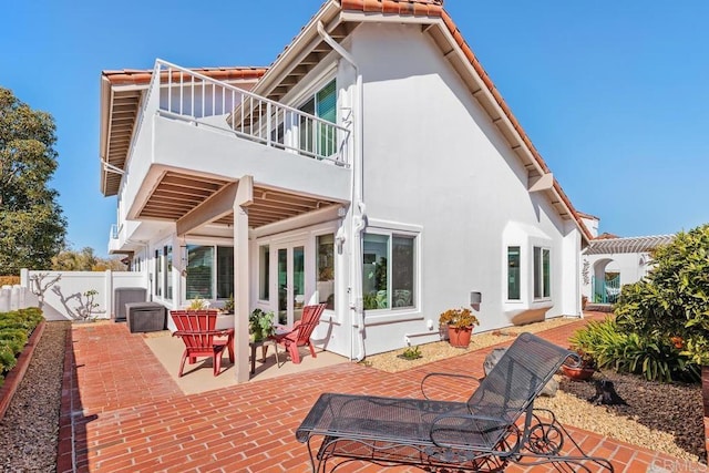 rear view of house with a patio, fence, french doors, and stucco siding