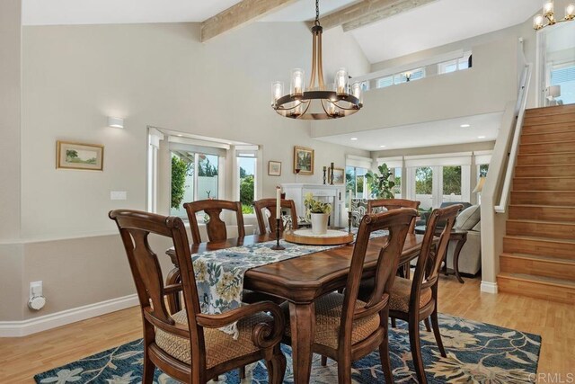 dining space featuring stairway, plenty of natural light, light wood-style floors, and a chandelier