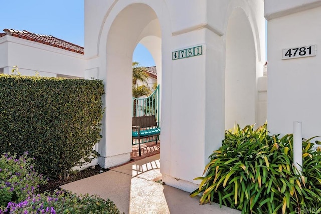 doorway to property with stucco siding and a tile roof