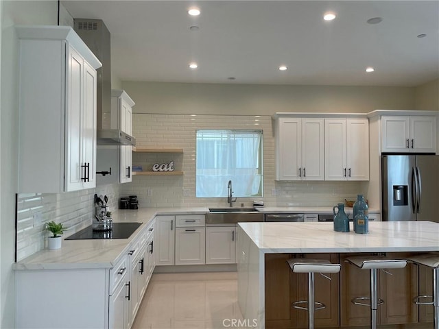 kitchen featuring a sink, appliances with stainless steel finishes, a breakfast bar area, and white cabinets