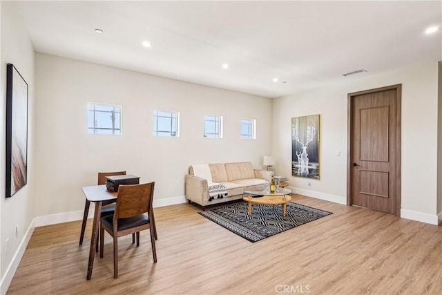 living area featuring visible vents, baseboards, recessed lighting, and light wood-style floors