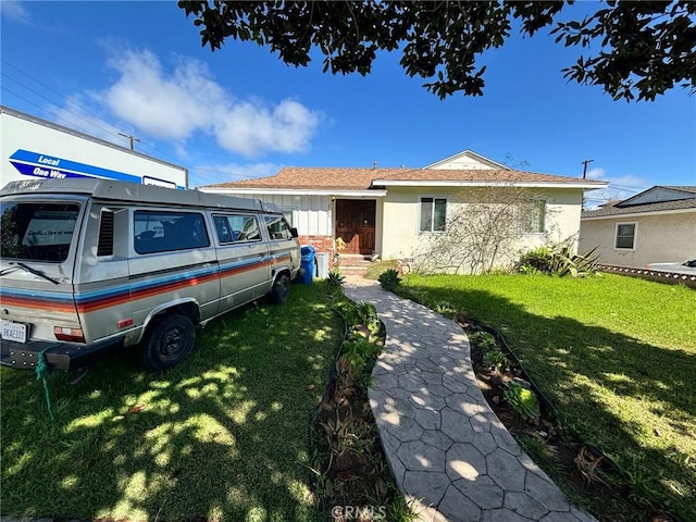 view of front of home with a front yard and stucco siding