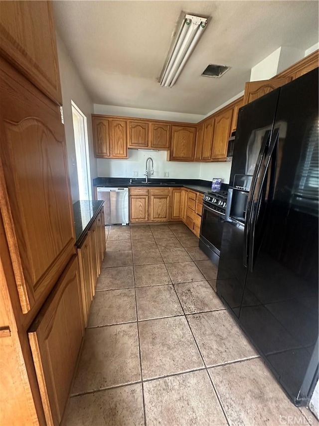 kitchen featuring a sink, visible vents, dark countertops, and black appliances