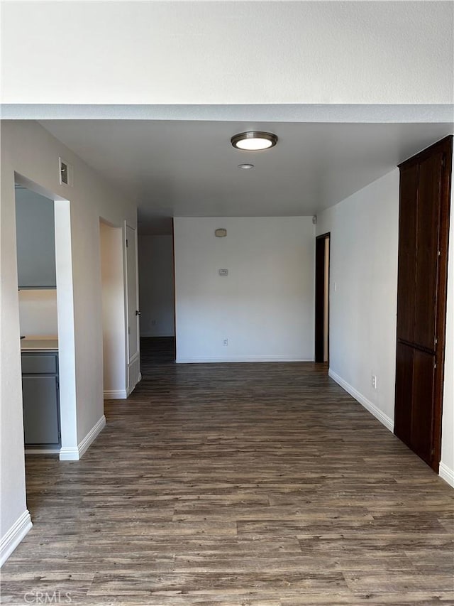 unfurnished room featuring visible vents, baseboards, and wood finished floors