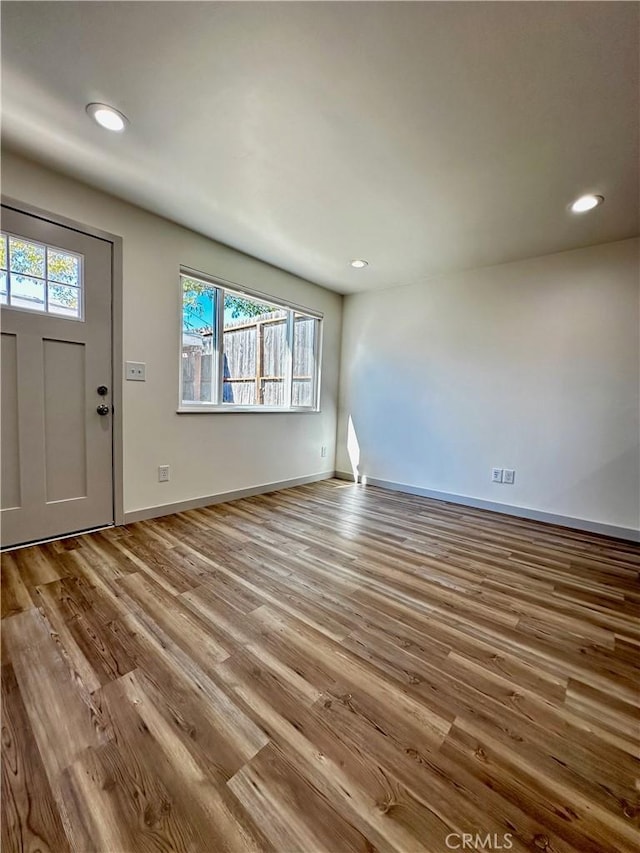 entrance foyer with a wealth of natural light, recessed lighting, baseboards, and wood finished floors