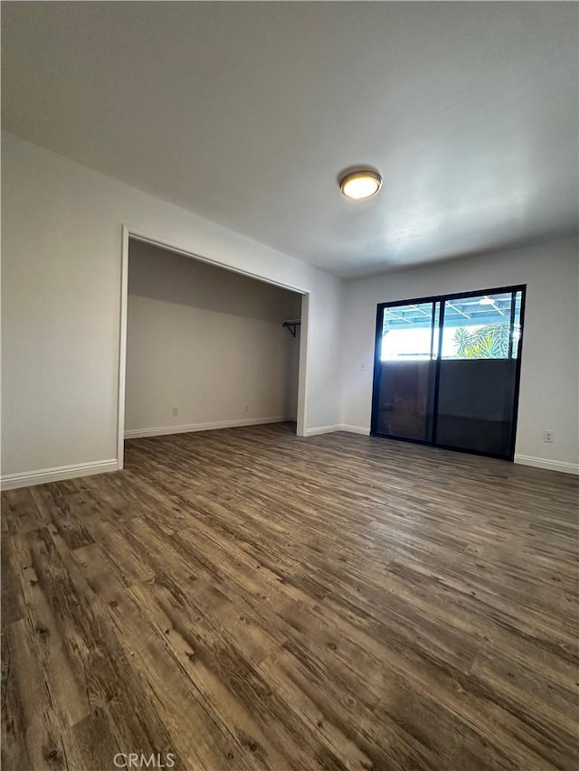 unfurnished bedroom featuring dark wood-style floors and baseboards