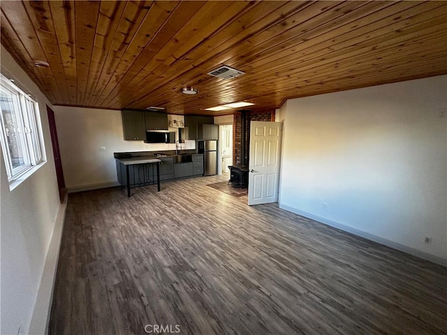 kitchen with visible vents, dark wood finished floors, open floor plan, appliances with stainless steel finishes, and a wood stove